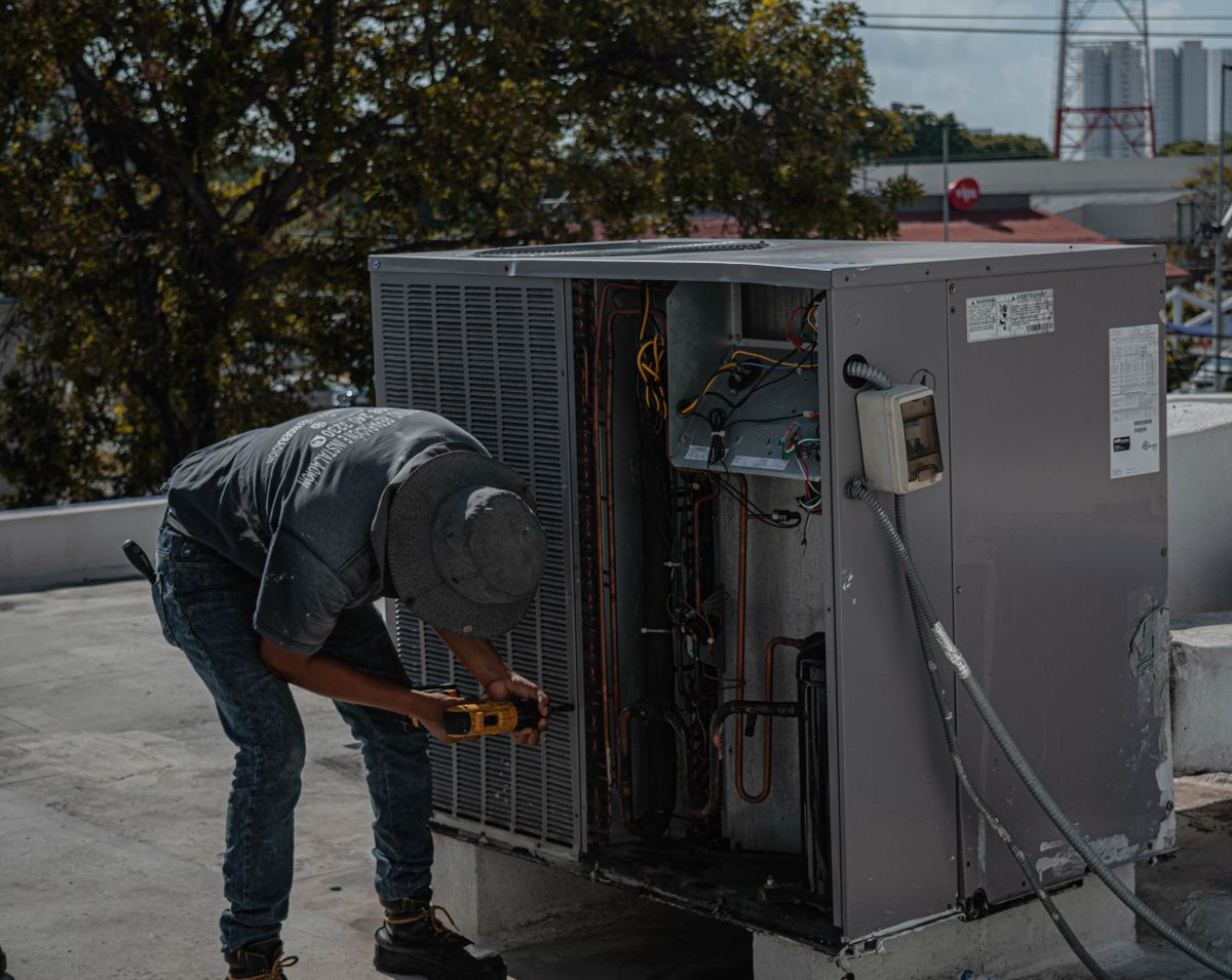 HVAC technician servicing a rooftop unit